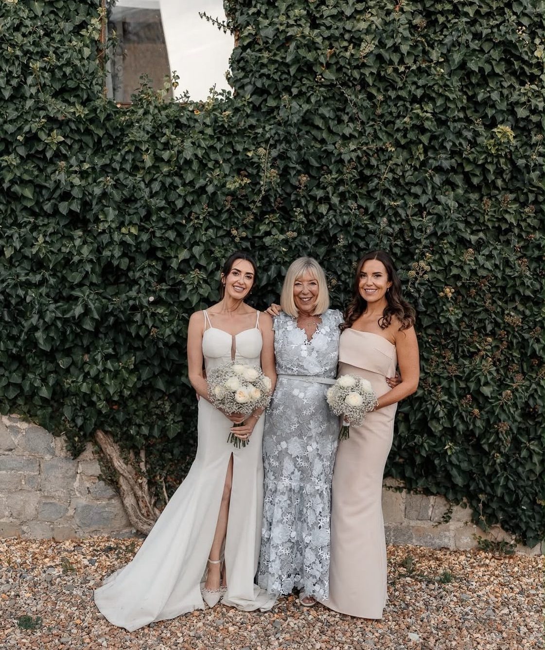 Bride with her mother and sister holding bouquets