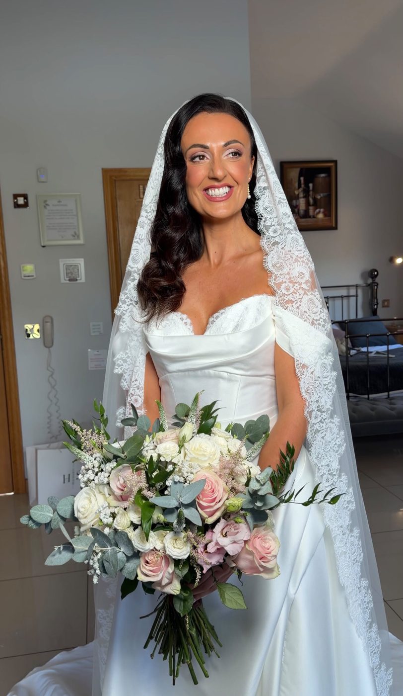 Bride holding a pastel rose and eucalyptus bouquet